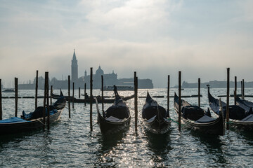 The gondolas, elegant guardians of stories and dreams in front of San Giorgio Maggiore, where the reflection of their colors dances on the water, creating a timeless enchantment. news Jeff Bezos