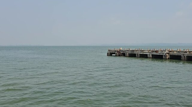 Dona Paula Pier, Dias Beach Access, Dona Paula, Panaji A serene view of the ocean with a rustic pier extending into the water