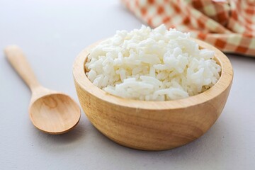 Cooked white rice or steamed rice in a wooden bowl, thai jasmine rice, thai fragrant rice on white table