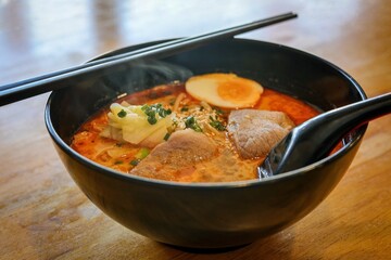 Spicy Ramen Tom Yum in a black bowl