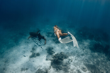 Underwater sea with freediver woman swims with nurse sharks in ocean