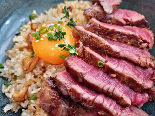 beef fat garlic fried rice with beef steak and topping with pickled egg yolk close up image 