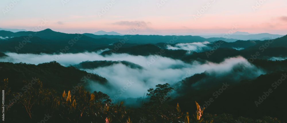 Poster Fog envelops distant mountains at dawn, creating a serene and mystical atmosphere