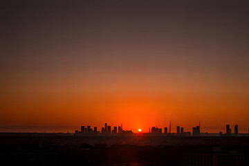 Scenic sunset over dark city silhouette
