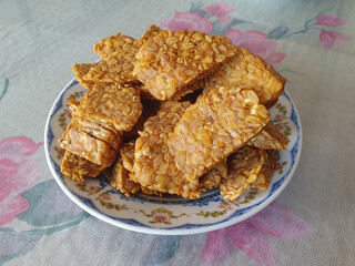 Tempe goreng. a plate of fried tempeh on the dining table