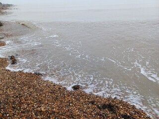 The sea and a shingle beach with the tide coming in waves