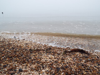 The sea and a shingle beach with the tide coming in waves