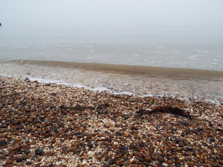 The sea and a shingle beach with the tide coming in waves