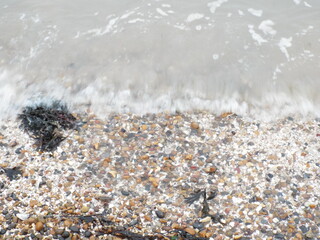 The sea and a shingle beach with the tide coming in waves