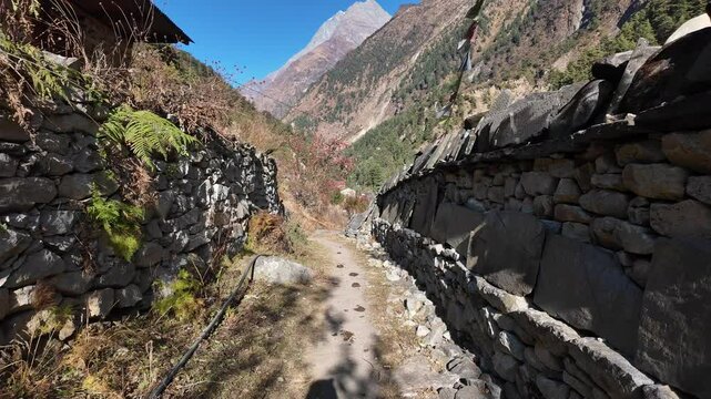 Manaslu, Nepal: Point of view of a trekker who walk along tibetan buddhist mani walls between Philim and Narung along the Manaslu circuit trek in the Himalaya in Nepal. 