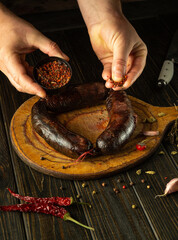 Expert hands prepare a delicious recipe while showcasing plump sausages and vibrant spices on a...