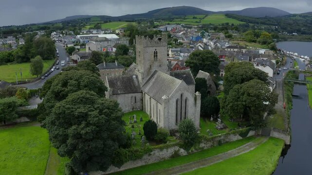 St Flannan's Cathedral, Killaloe, County Clare, Ireland, September 2021. Drone orbits counter clockwise around the medieval architecture surrounded by a cemetery on the banks of the River Shannon.