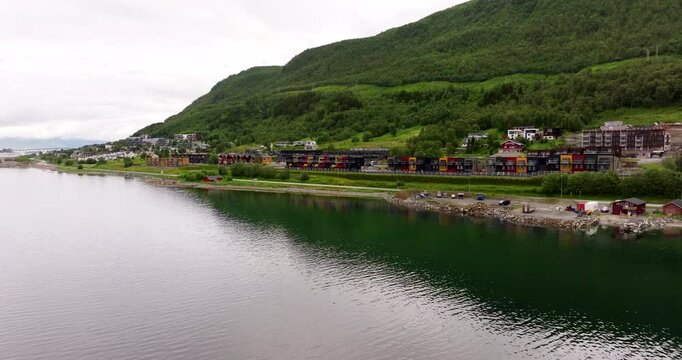 Colorful Waterfront Apartments Along The Coastal Road Of E8 Route In Tromso, Norway. Aerial Pullback Shot