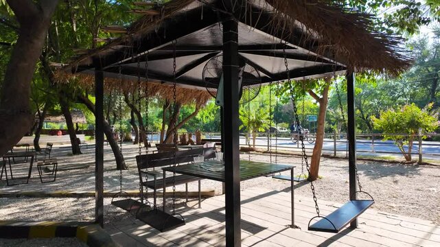 Gazebo with table, bench and swings at Ayub National Park with greenery in the background