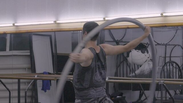 A man practices on a Cyr wheel, demonstrating his balance, coordination, and strength in a gymnasium