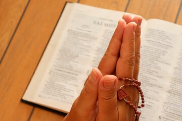Woman praying on holy bible. Holding hands with Crucifix and Bible in Prayer.  