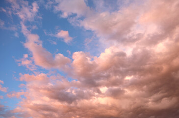 romantic background of the blue sky and soft pinkish clouds with sunlight filtering through