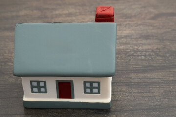 Troubled housing market with a house on weathered wood desk