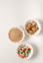 Raw ingredients for Tilgul, a sweet made on the occasion of Makar Sankranti. Bowl of sesame seeds,...