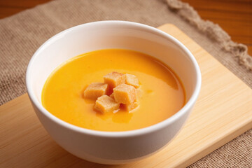 Creamy orange soup in ceramic bowl served