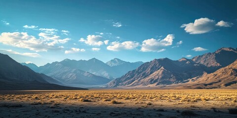 Naklejka premium Breathtaking scenic view featuring majestic mountains set against a clear blue sky, capturing the beauty of nature s landscapes and the tranquility of wide open spaces.