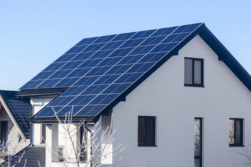 Fototapeta premium Solar Panels in Winter are more Effective at Generating Energy in Colder Temperatures. Solar Panel Station on Modern Private House Roof.