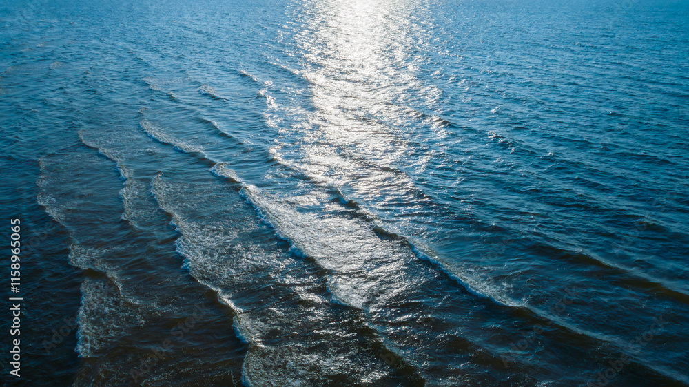 Aufkleber top view of Ocean blue and calm with sun rays reflection on smooth waves as textured blue background for banner template or web page design. Water calm with smooth waves.