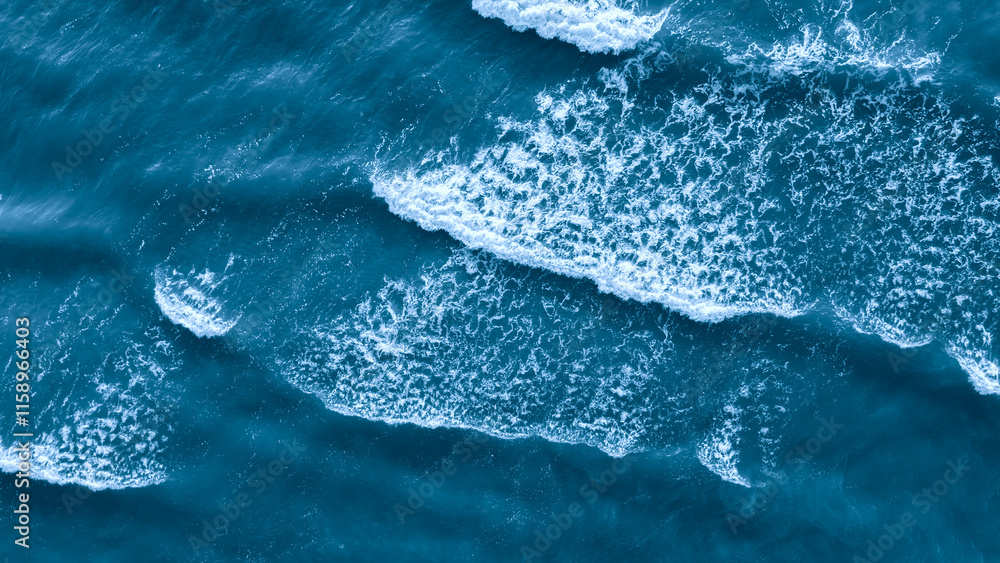 Poster Ocean is blue and has waves as a flat textured blue background top view for web page banner template design. The waves are small and crashing on the shore. water is calm and peaceful.