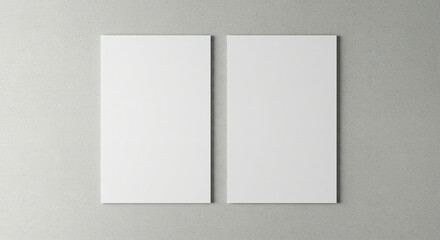 Two empty white vertical rectangle poster mockups with soft shadows on neutral light grey concrete wall background. Flat lay, top view