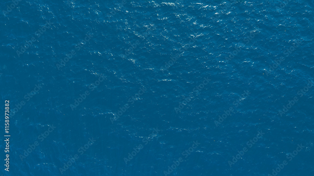 Poster Flat lay top view of Ocean blue and calm with sun rays reflection on smooth waves as textured blue background for banner template or web page design. Water calm with smooth waves.