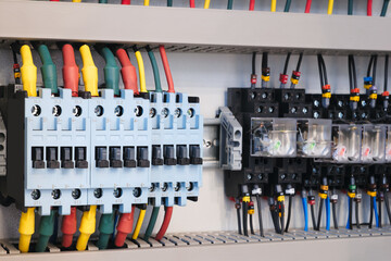 Bunch of electrical switches are hanging on a wall. The switches are in different colors and sizes