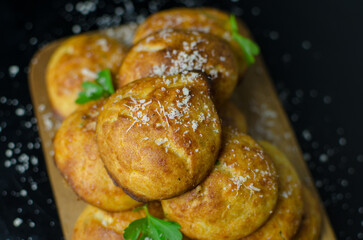 Traditional French Gougeres - savory cheese choux pastry profiteroles on a wooden board - close up