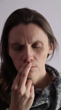 Female tapping EFT technique under nose point on a face. Vertical video.