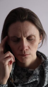 Female tapping EFT technique side of eye point on a face. Vertical video.
