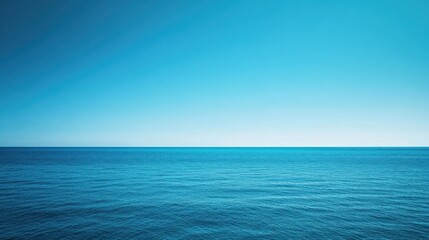 Obraz premium Ocean view under vast clear blue sky with gradient towards horizon