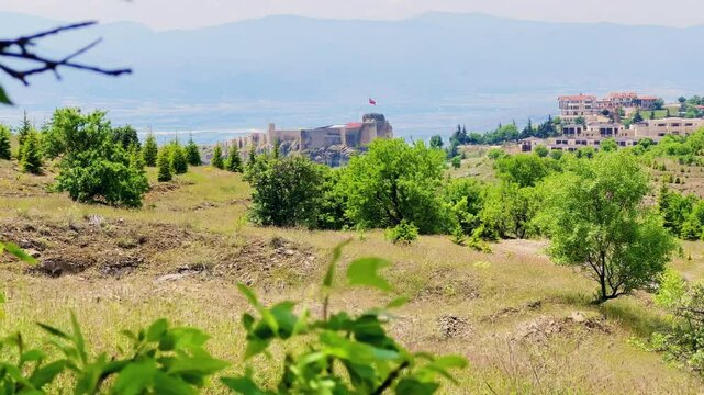 Harput fortress with the Turkish flag, in the spring in Eastern Anatolia, Elazig, Turkey. Harput Castle or Harberd, also known as Sut Kalesi. Ancient city. 4К