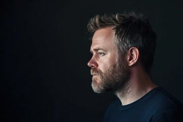 Naklejka premium Profile Portrait of a Thoughtful Man in Shadow