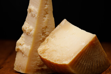 Traditional Italian cheeses Rodez and Parmesan close-up on black background