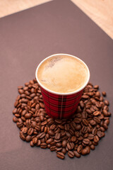 Paper cup with coffee on roasted coffee beans	