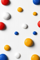 Abstract pattern of colorful paint blobs on white surface
