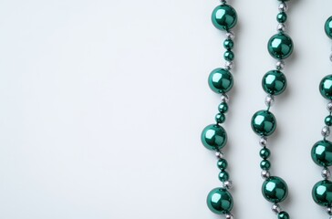 Obraz premium Elegant Green Beads and Shiny Silver Accents Arranged on Light Background for Jewelry Design, Crafting, and Decorative Purposes