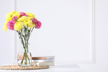 Beautiful chrysanthemum flowers in vase on table indoors. Space for text