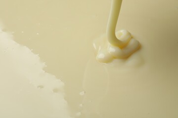 Pouring delicious condensed milk as background, closeup