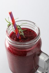 Fresh beetroot smoothie in mason jar on light background, closeup