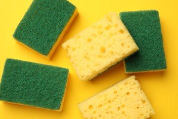Soft sponges on yellow background, flat lay. Cleaning tool