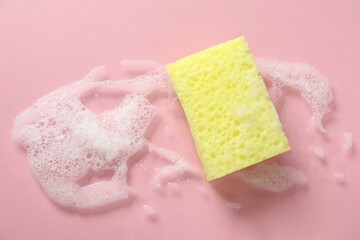 One cleaning sponge and foam on pink background, top view. Space for text