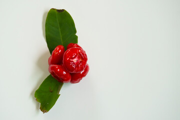 Small, bright red guava on a white background