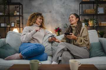 Naklejka premium two friendly women use cellphone and credit card make payments online