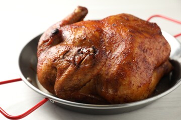 Delicious baked turkey in baking dish on light table, closeup