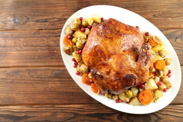 Delicious baked turkey, vegetables and cranberries on wooden table, top view. Space for text